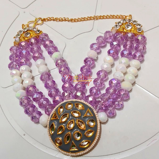 A multi-strand traditional Indian statement necklace featuring faceted light purple beads, white pearl-like beads, gold chain, and a large round gold-toned pendant with a gray-blue center.